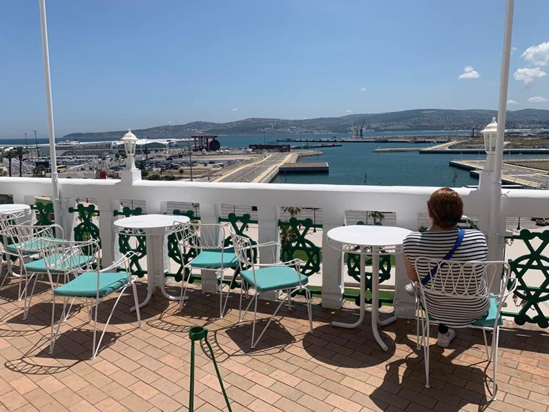 image of a person sitting at a table on a rooftop.