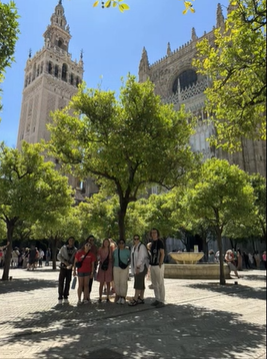 A photo of a group of people posing under a tree.