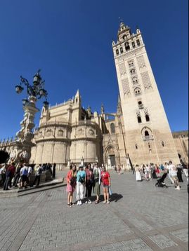 A photo of a group of people posing in front of a building.