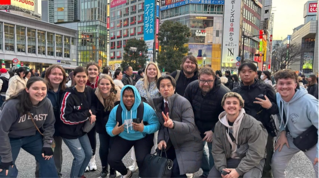 A photo of a group of people posing in a city.