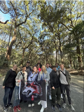 A one photo of a group of people posing in the woods.