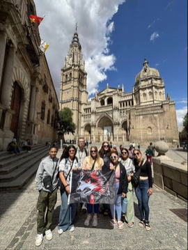 A photo of a group of people posing in front of buildings.