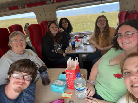 A photo of a group posing for a selfie on a train.