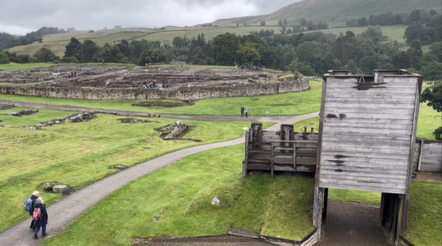 A photo of archaeological ruins with wooden buildings