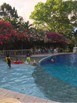 A photo of five people swimming in a swimming pool.