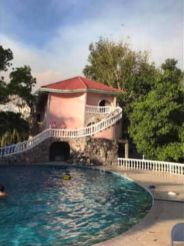 A photo of a building behind a pool.