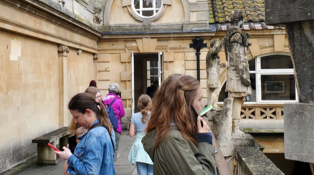 A photo of people looking at the Roman Baths.