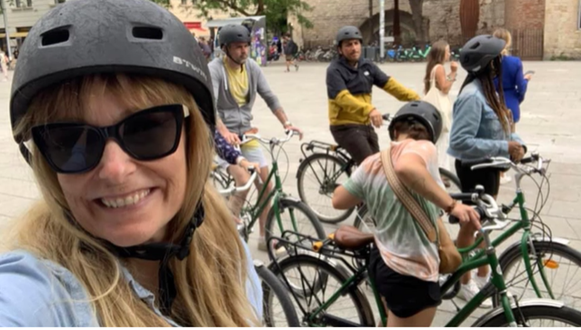 A photo of a group of people on bikes with one person posing for a selfie.