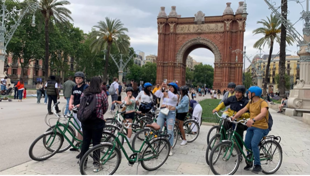 A photo of people on bikes stopping to see the city.