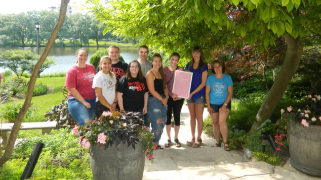 A photo of a group of people posing outdoors.