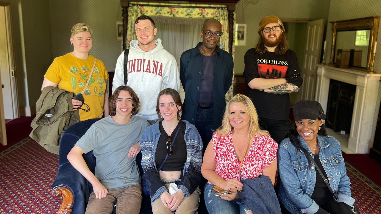 A photo of a group of people posing in a room.