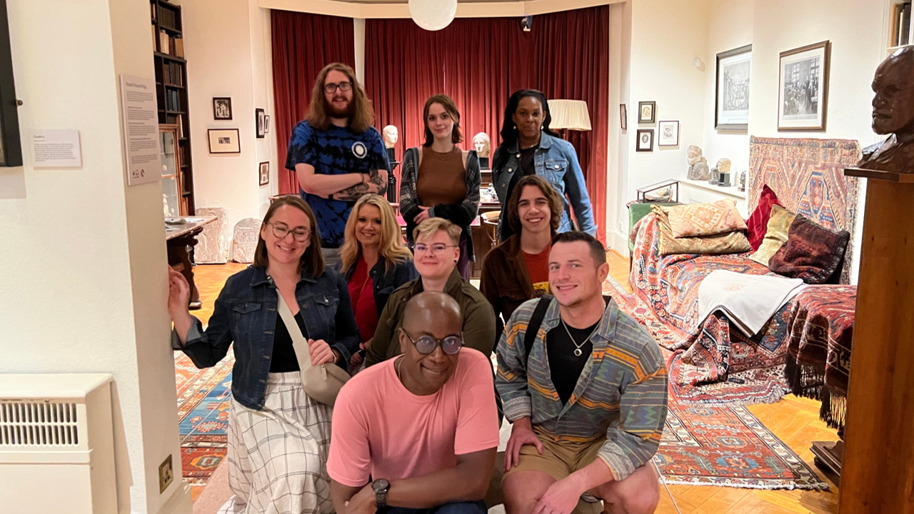 A photo of a group of people posing in a living room.