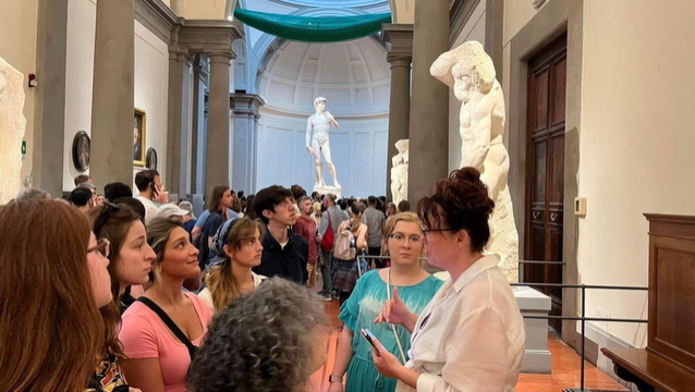 A photo of a group of people examining statues.