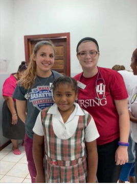 A photo of two people posing with a child.