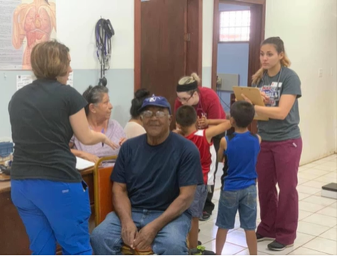 A photo of three nursing students talking with a group of people.