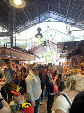 A photo of a group of people shopping in a market.