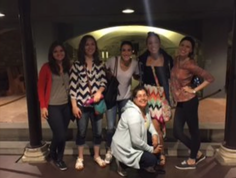 A photo of a group of people posing in a dark room.