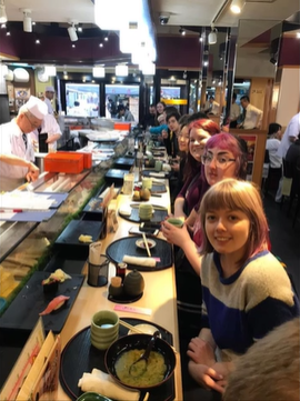 A photo of a group of people posing in a restaurant.