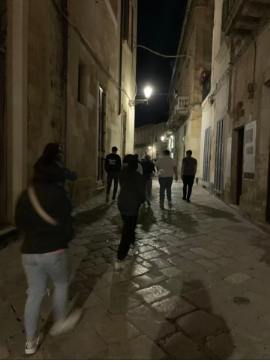 A photo of a group of people walking down a dark street.