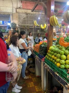 A photo of a group of people looking at fresh produce.