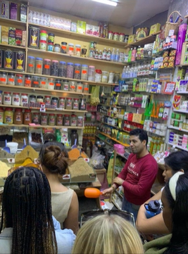 A photo of a group of people listening to a shopkeeper.