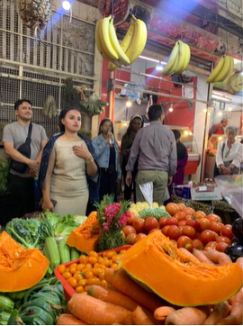 A photo of a group of people standing in front of fresh produce.