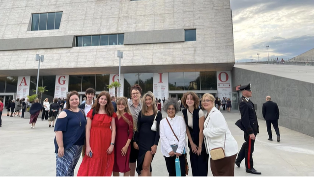 A photo of a group of people posing outside the Maggio Musicale Fiorentino.