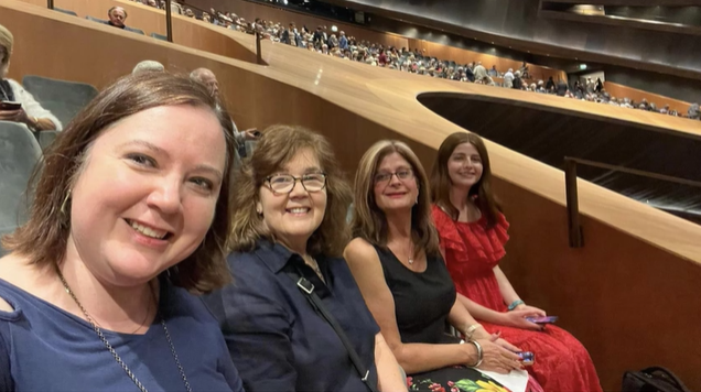 A photo of four people posing for a selfie inside the Maggio Musicale Fiorentino.