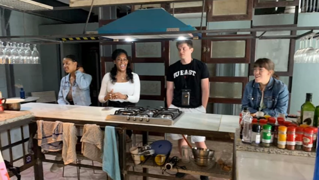 A photo of four people in a kitchen.