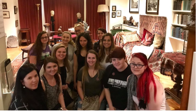 A photo of a group of people posing in a living room.