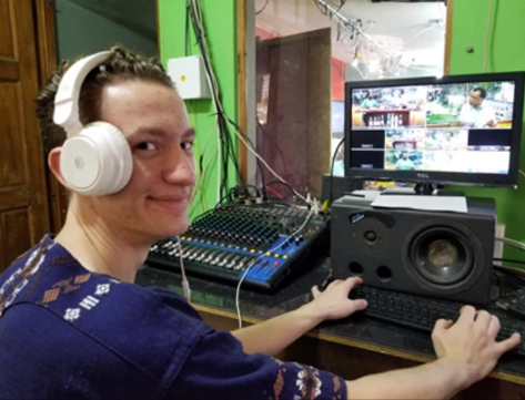 A photo of a person in front of video editing equipment.