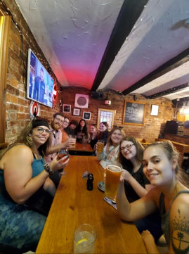 A photo of eleven people posing for a selfie in a pub.