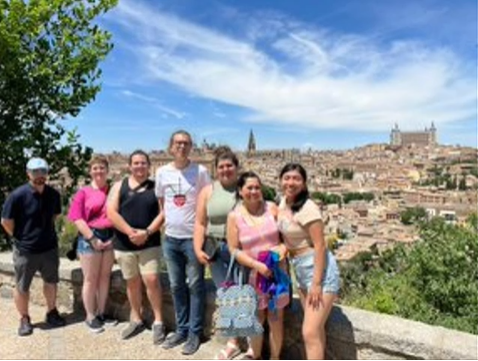 A photo of a group of people posing on a terrace.