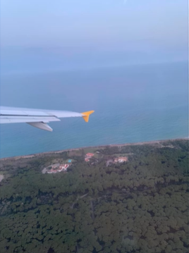 A photo of a plane wing over water.