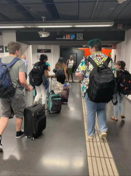 A photo of a group of people walking through an airport.