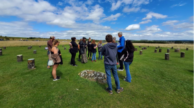 A photo of a group of people visiting woodhenge.