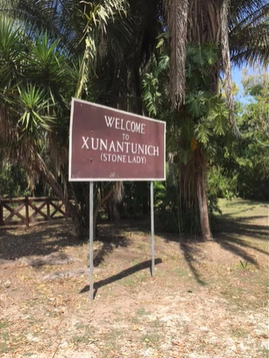 A photo of a sign which reads "Welcome to Xunantunich (stone lady)".