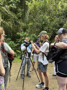 A group of people standing around a camera.