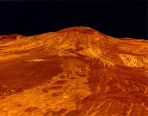 A photograph of the surface of planet Venus is shown. The lava flows on Venus are shown as orange red color of the surface.