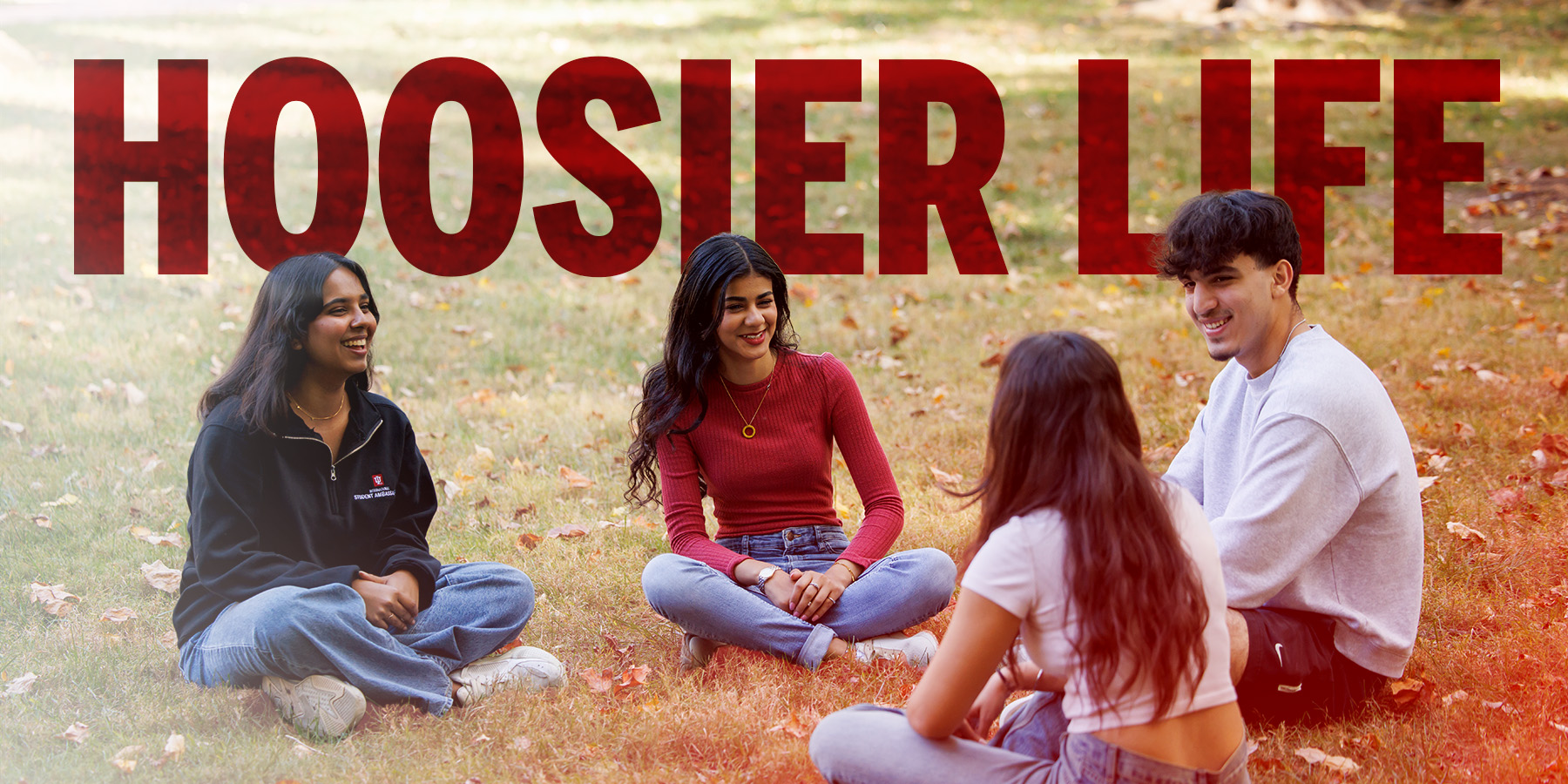 Four tudents sitting in a circle in Dunn Meadow.