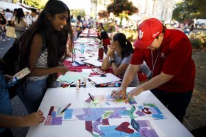 Students create art at a table during the First Thursdays Festival on the Arts Plaza at IU Bloomington.