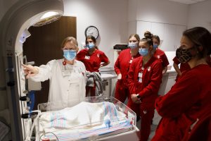 Image of a professor and students before the start of a delivery room simulation inside the IU Health Sciences Building.