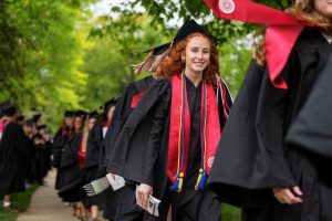Graduates walk through a faculty cheer tunnel as part of the processional during the IU Kokomo Commencement.