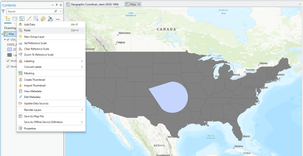 creenshot of GIS software showing a map of the United States with state boundaries outlined in dark gray. A large, light blue teardrop-shaped area is centered over the central U.S. The left-side menu includes options like "Add Data," "New Group Layer," and "Set Reference Scale." The top bar displays the file name "Geographic Coordinate.sdm (WGS 1984).
