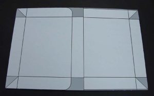 Piece of corrugated board marked for cutting and creasing