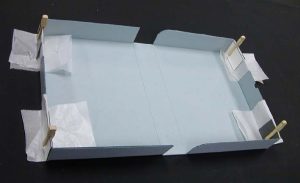 Clamshell box with corners glued together and set to dry with waxed paper and clips
