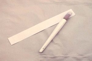 Applying glue to the spine lining paper