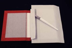 The text block poitioned on the cover, prepared to glue up the cloth hinges of the endsheets and spine lining