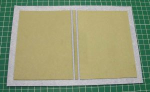 Board and spine inlay affixed to cloth and cloth edges trimmed