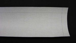 Piece of cloth cut for the front wall and sides of the A tray. marked on a long and shirt edge at 2.5 cm.
